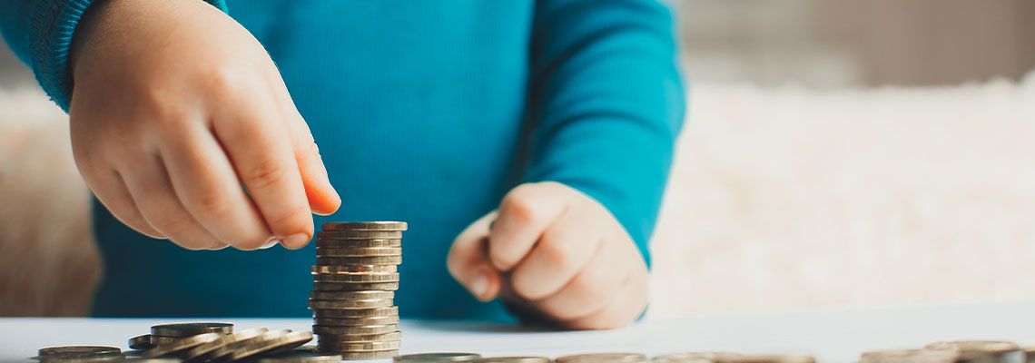 Child arranging stack of coins