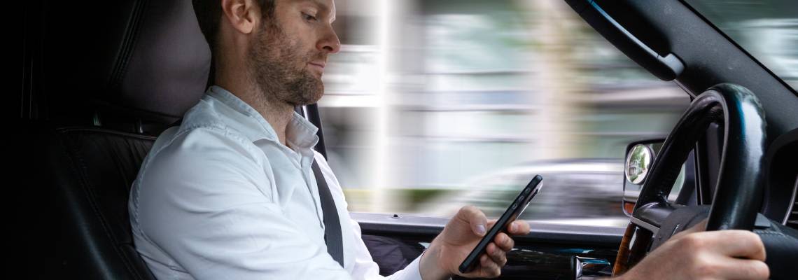 Man using phone while driving car
