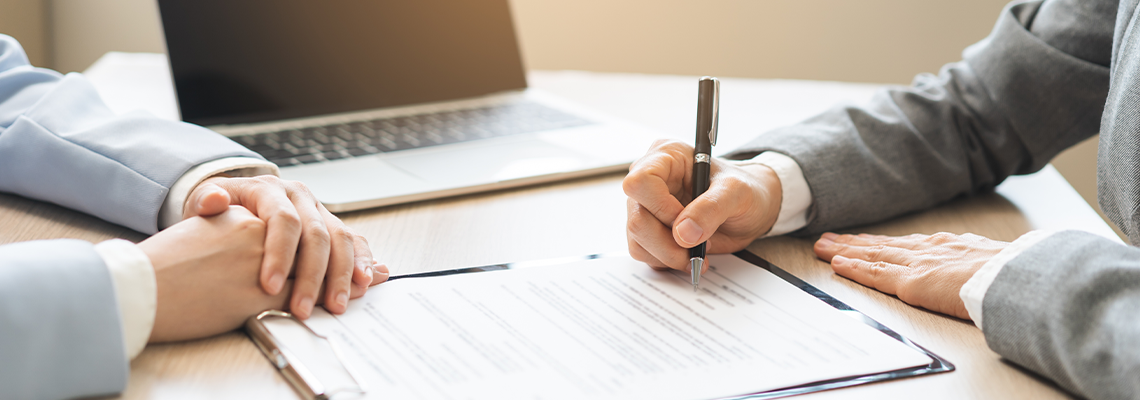 Close up of business people hands signing contract agreement document