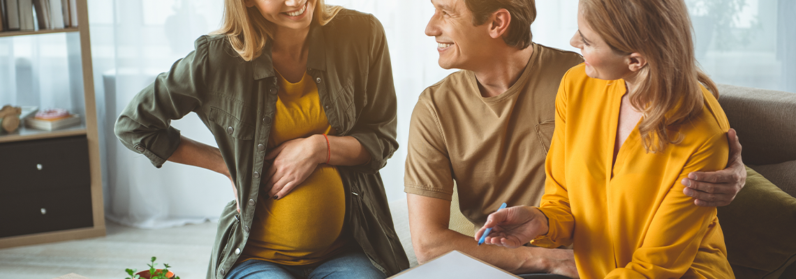 Pregnant woman is looking is looking at paper with satisfaction
