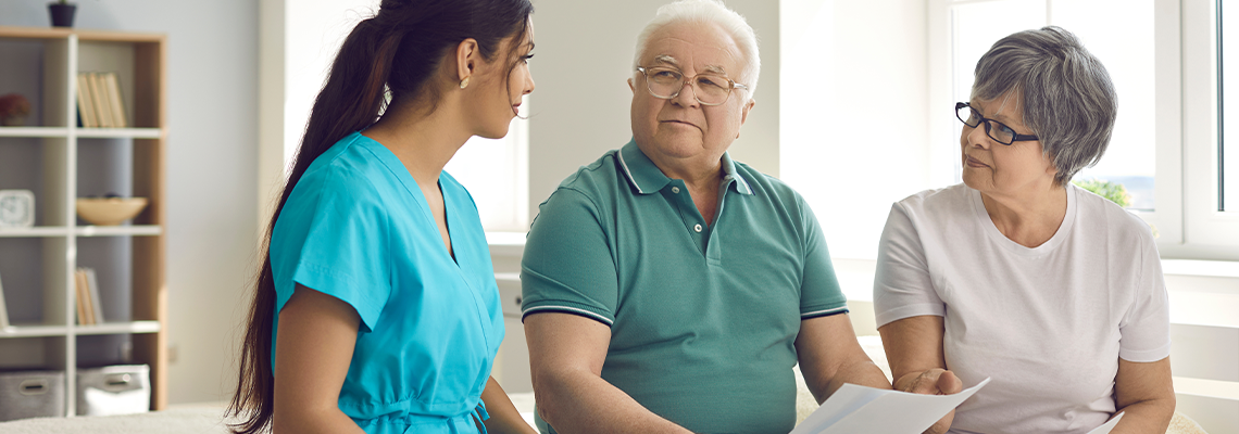 Caretaker helps senior patients sign homecare agreement, fill informed exam consent