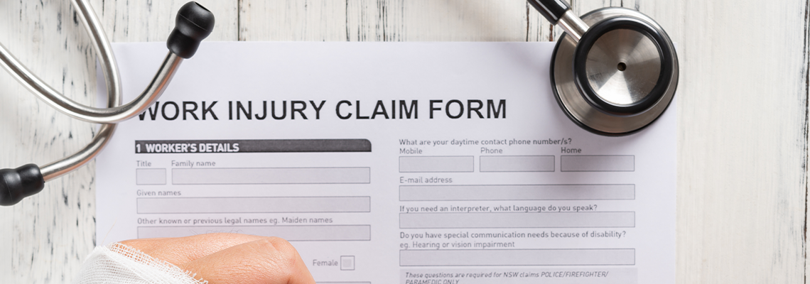 Top View Man Filling up A Work Injury Claim Form with Stethoscope