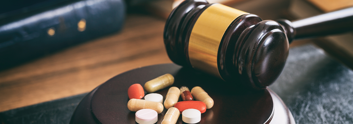 Judge gavel and drugs on a wooden desk