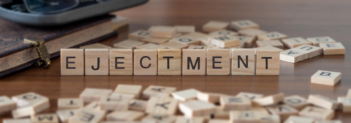Ejectment word or concept represented by wooden letter tiles on a wooden table