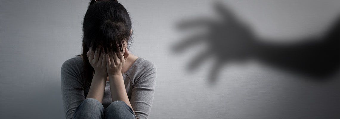 Sexual abuse victim crying with approaching hand shadow