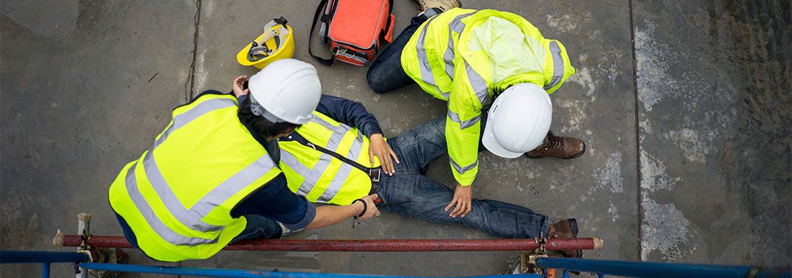 Workers helping injured worker in construction site
