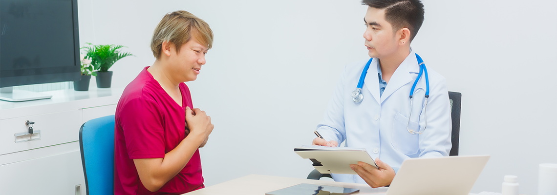 Male doctor consults with a male patient in a red shirt about men's health concerns