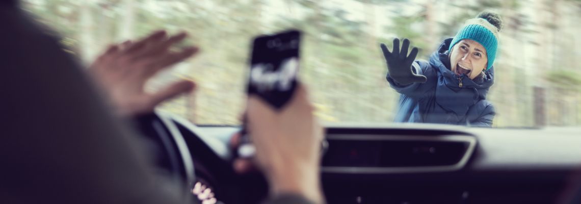Man using phone while driving about to hit a pedestrian