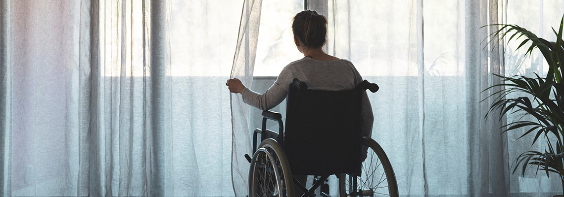 Woman in wheelchair at home alone