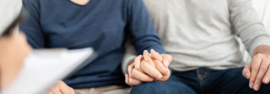 Two people sitting and holding hands