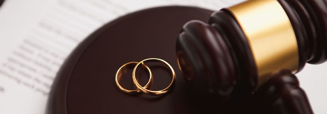 Divorce concept with gavel and wedding rings