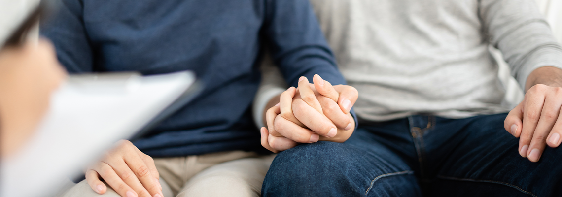 Young couple holding hands during meeting with attorney