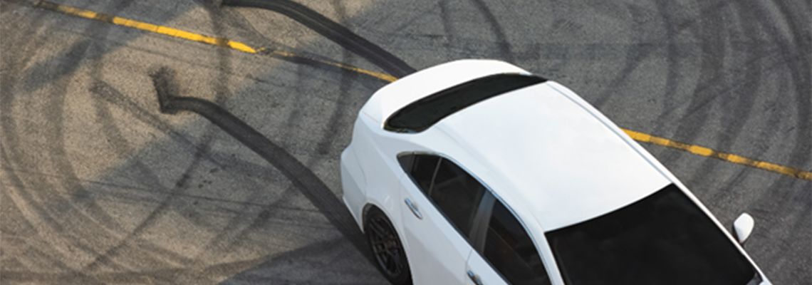 Car in parking lot with skid marks