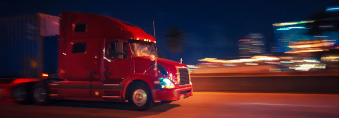Semi Truck Driving with Blurred City Lights