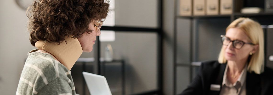 Women with neck injury consulting with attorney
