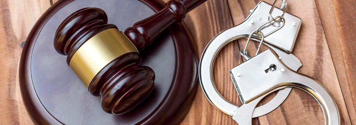 Judge's gavel with handcuffs on the table