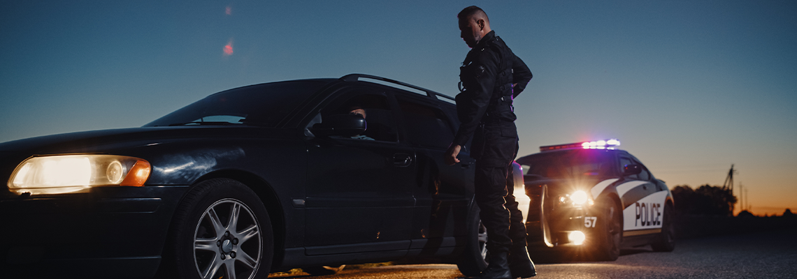 Portrait of Middle Aged Caucasian Cop Approaching a Pulled Over Car with Caution
