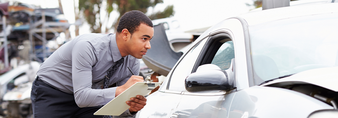 Loss Adjuster Inspecting Car Involved In Accident