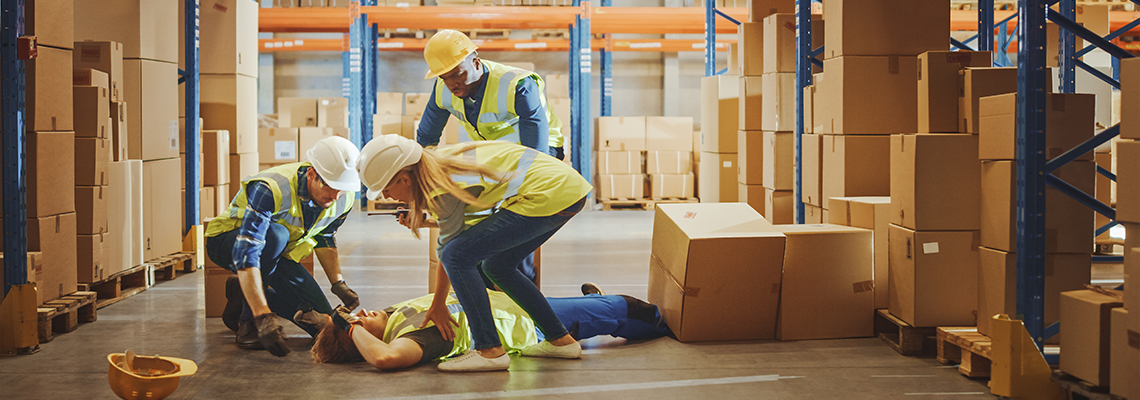 Person in warehouse on the ground surrounded by coworkers