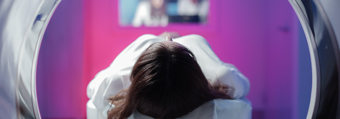 The girl patient is lying in the tomograph and waiting for a scan.