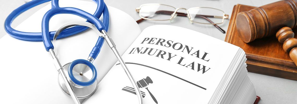 personal injury law book and stethoscope on table