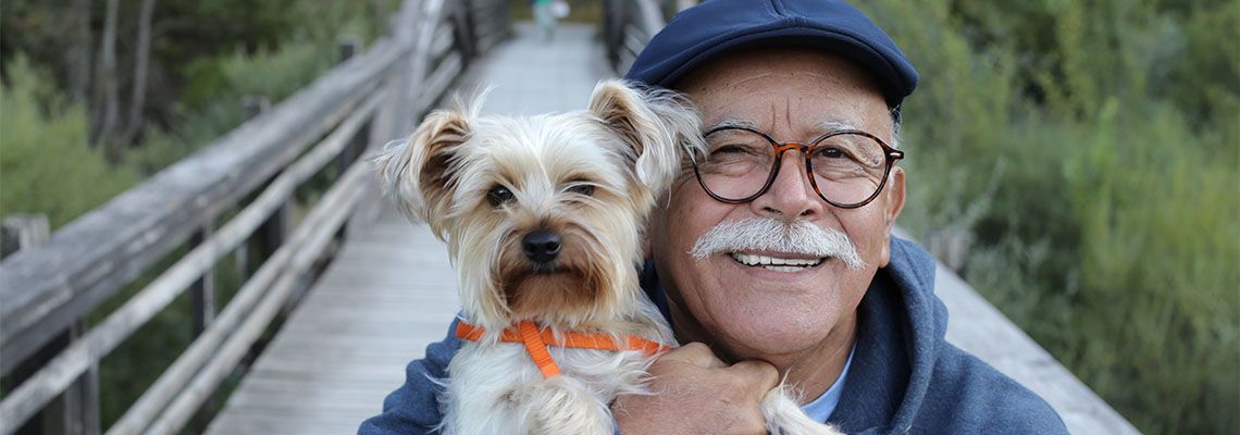 Old man holding pet dog in hand