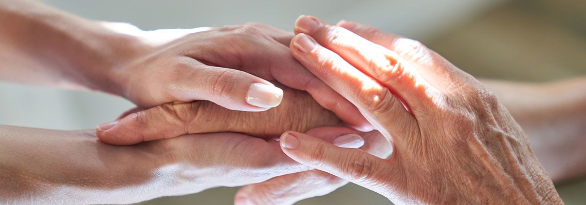 Young hands securely holding old person's hand
