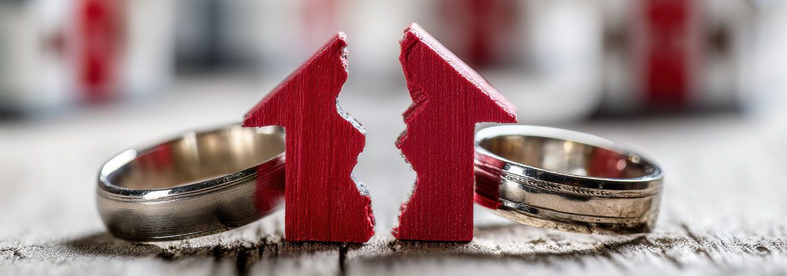 Wedding ring and divided house model in table
