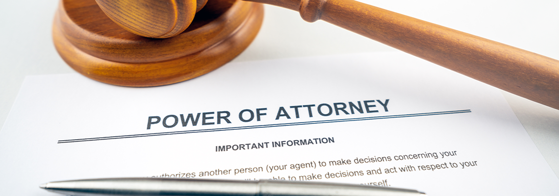 Power of attorney text on contract with pen, gavel and glasses