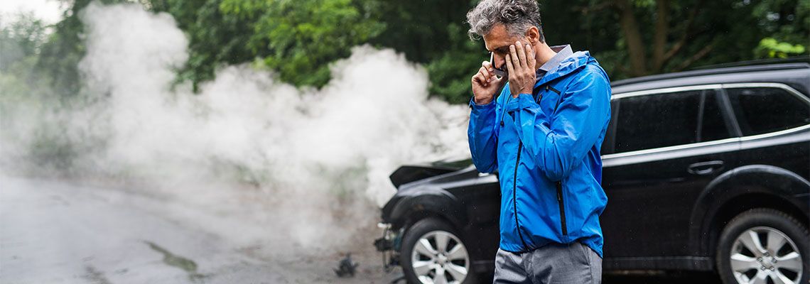 Man making a phone call after a car accident