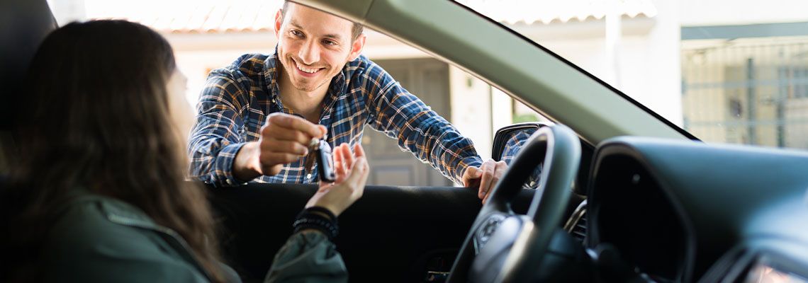 Dad giving car keys to teenage girl