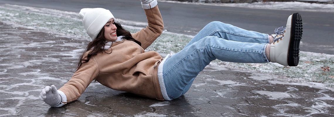 Women slips and falls on icy sidewalk