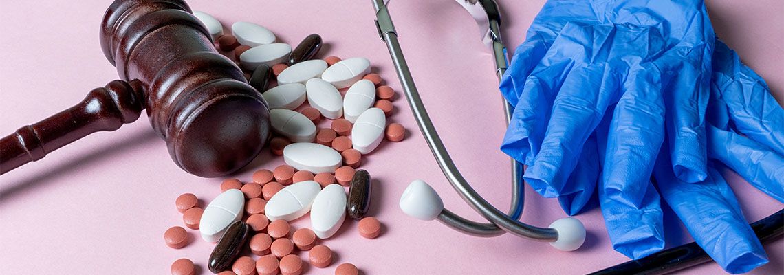 Gavel, Medical Pills, Stethoscope and Gloves in table