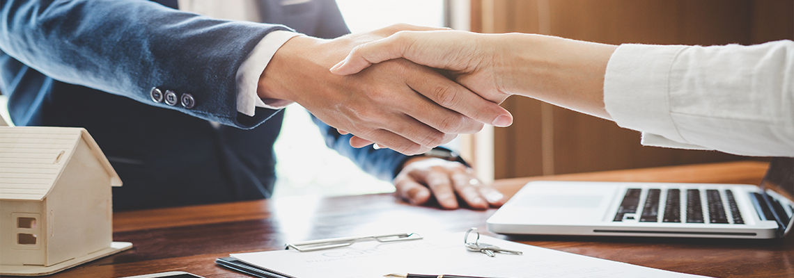 Estate agent and customer shaking hands after finished contract