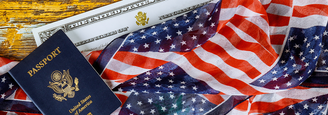 US passport and flag over a citizenship and naturalization certificate