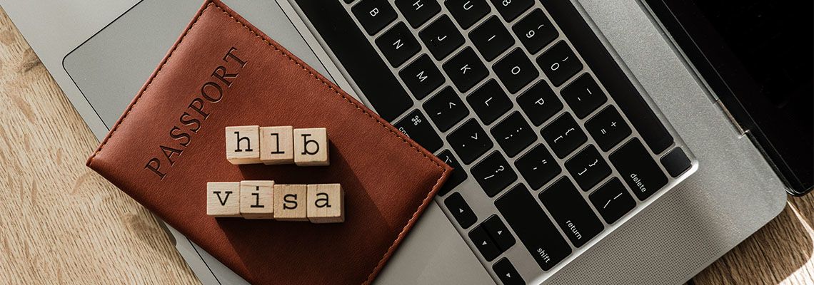 H1B visa wooden blocks on passport and laptop