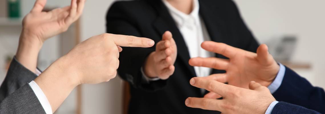 Hands of arguing clients at mediator's office