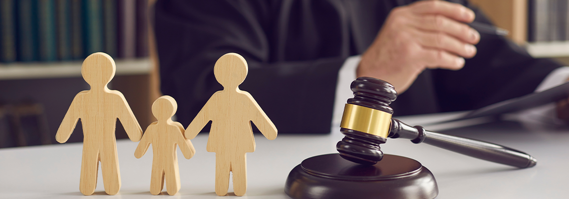 Gavel, sound block and small wooden figurines of husband, wife and kid