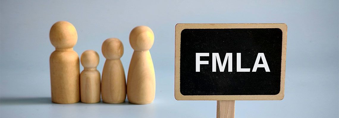 Wooden family figures with FMLA written on board