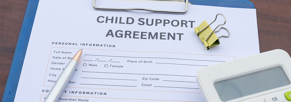 A child support contract clipped in a clipboard with money
