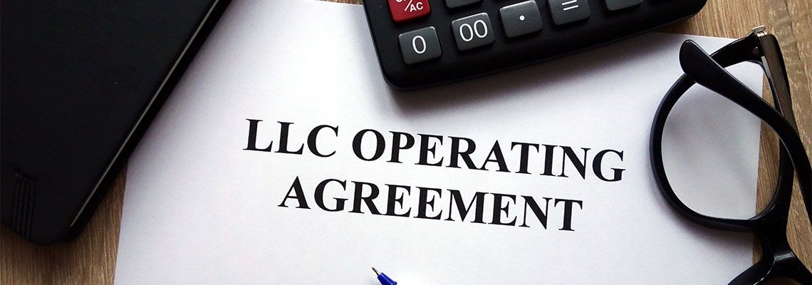 LLC operating agreement with pen and glasses at table
