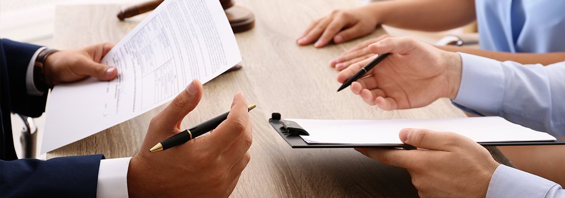 Lawyer working with clients at table in office, focus on hands