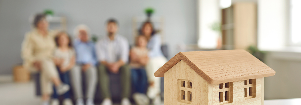 Closeup small little wooden toy house on table, whole big family