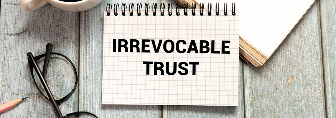 IRREVOCABLE TRUST text on sticker with pen on the black background