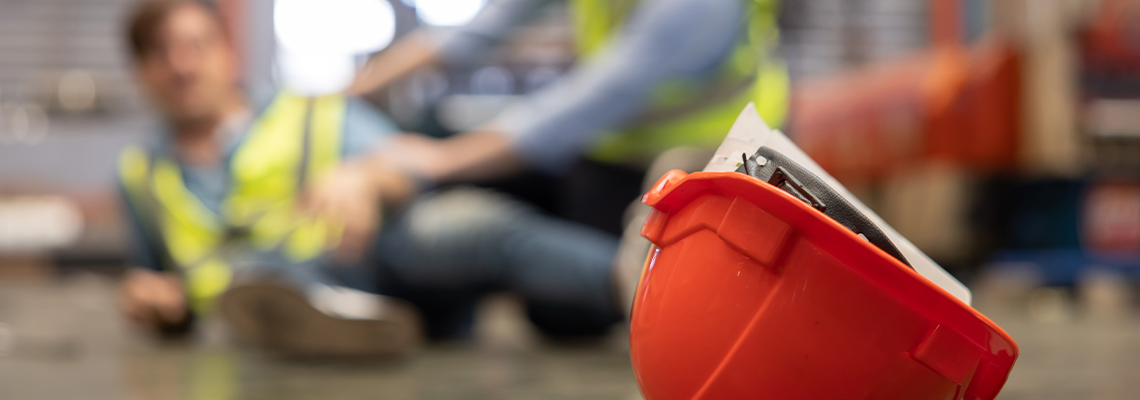Red Hard Hat with Blurred Injured Factory Workers