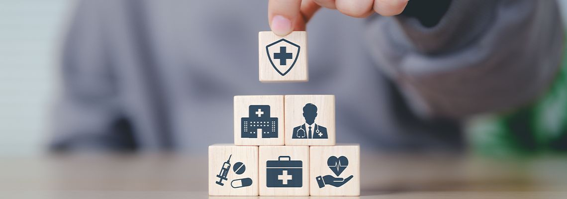 Hands placing wooden blocks with health-related icons
