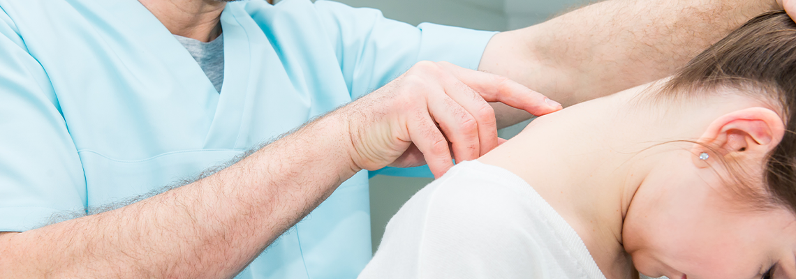 Male neurologist doctor examines cervical vertebrae of female patient