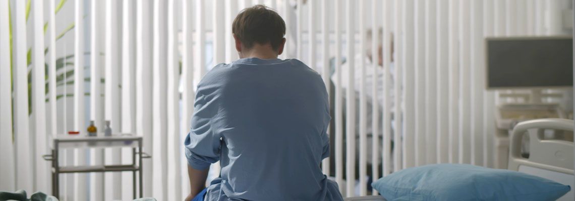Sad injured man in hospital bed