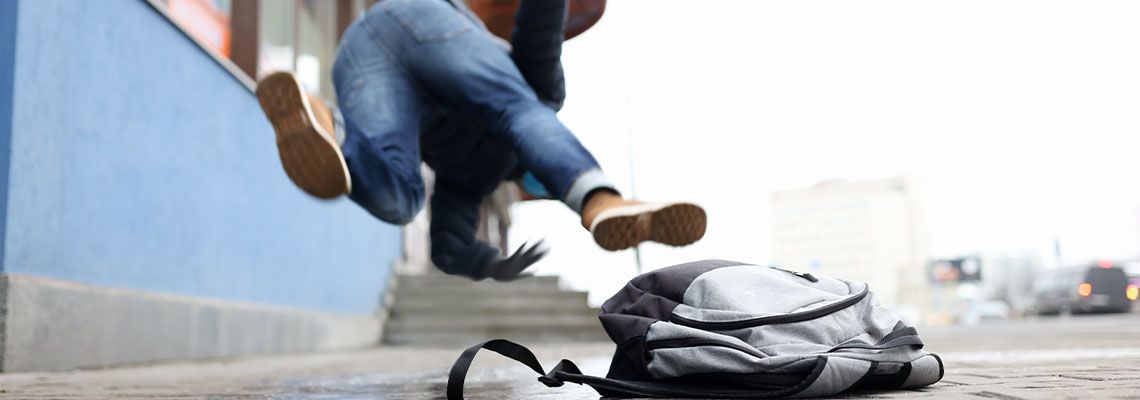 Person slips and falls in an icy pavement