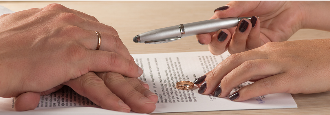 Person giving another person a ring and pen on documents